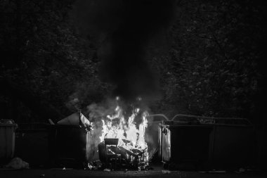 Diğer çöp ile çöp konteyner ve eski ahşap sandalye yanan. Plastik çöp tenekesi neredeyse erimiş
