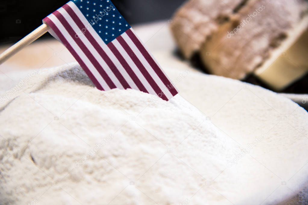 USA flag in flour, slices of bread on the background, dark tone. Financial crisis, poverty, great depression concept.