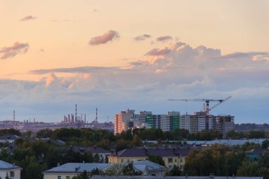 Şehir silüeti üzerinde gün batımında destansı fırtına bulutları