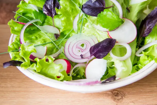 Frischer grüner Salat mit Rettich, Salat, roten Zwiebeln und Basilikumblättern. Rohkost und vegane Ernährung — Stockfoto