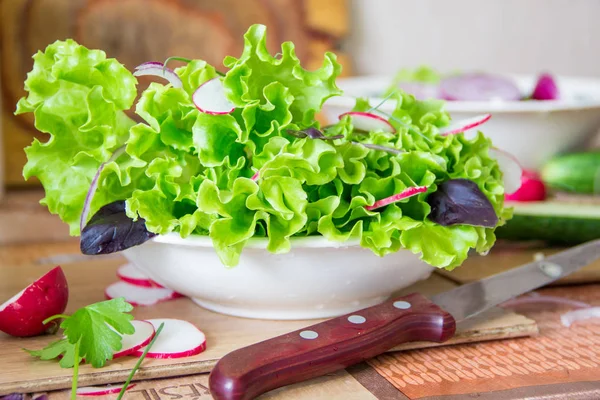 Salat mit Rettich, Salat, roten Zwiebeln und Basilikumblättern zubereiten. Ernährung oder vegetarisches Ernährungskonzept — Stockfoto