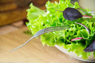 Turp, marul, kırmızı soğan ve fesleğen yaprakları ile salata hazırlanıyor. Diyet veya vejetaryen gıda kavramı. tarafında kaybolan çatal