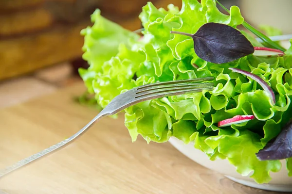 Salat auf dem Tisch mit Rettich, Salat, roten Zwiebeln und Basilikumblättern. Ernährung oder vegetarisches Ernährungskonzept — Stockfoto