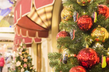 Alışveriş merkezinde Noel ağacı arka plan ve Noel süslemeleri. Yeşil köknar renkli topları ve spor ayakkabıları oyuncaklar. Yeni Yıl teması