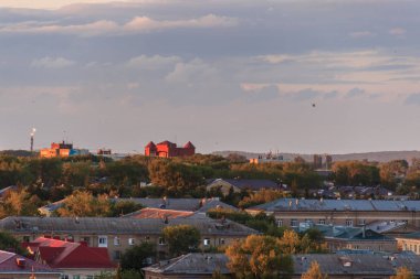 Gün batımında küçük bir Sovyet şehri. Güneş bulutların arkasından doğur..