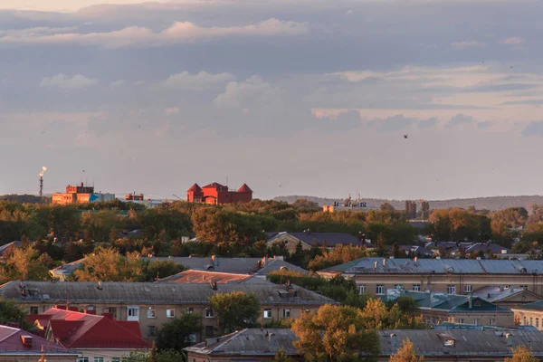 Gün batımında küçük bir Sovyet şehri. Güneş bulutların arkasından doğur..