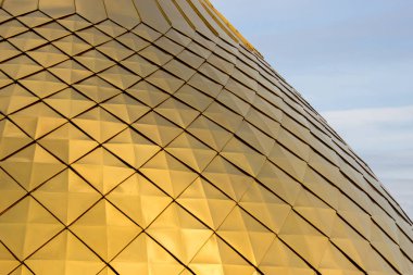 Mavi gökyüzünde eşkenar dörtgen desenleri ile parlak altın kubbe dokusu, yakın çekim