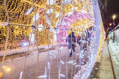 İnsanlar ve turistler, yılbaşı ve noel tatilleri için dekore edilmiş Tverskaya caddesi boyunca yürüyorlar. Festival Noel ışığı