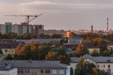 Şehir silüeti üzerinde gün batımında fırtına bulutları