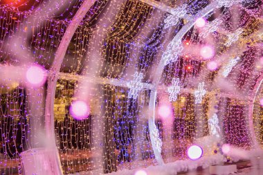 Renkli ampuller ve ışık tünelinde led kar taneleri. Noel sokak süslemeleri, şehirde yeni yıl hazırlığı. Soyut bulanık arka plan