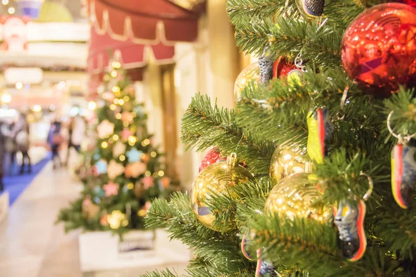Alışveriş merkezinde Noel ağacı arka plan ve Noel süslemeleri. Yeşil köknar renkli topları ve spor ayakkabıları oyuncaklar. Yeni Yıl teması