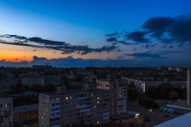 Şehir silüeti üzerinde gün batımında destansı fırtına bulutları