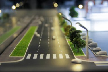 Şehir sokakları, arabalar, binalar, akşam aydınlatma ile yollar bir düzenin parçası. Şehir mimari modeli, maquette