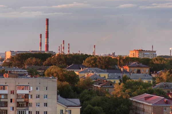 Liten sovjetisk stad vid solnedgången. Solen kommer ut bakifrån molnen. — Stockfoto