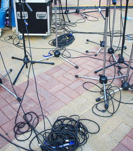 Zavřít pohled na zamotané černé dráty, kabely a stojánek na mikrofon na zemi, chaos po koncertě — Stock fotografie