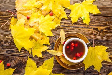 Ahşap doku arka plan üzerinde sarı düşmüş akçaağaç yaprakları.