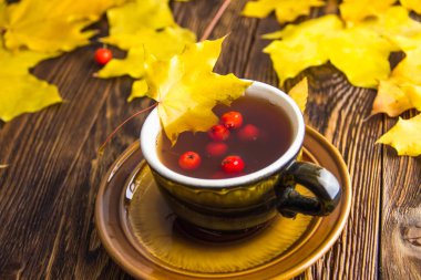 Koyu kahverengi ahşap masa arka plan üzerinde sarı ve turuncu düşmüş akçaağaç yaprakları.