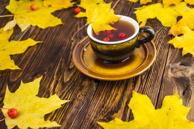 Koyu kahverengi ahşap masa arka plan üzerinde sarı ve turuncu düşmüş akçaağaç yaprakları.