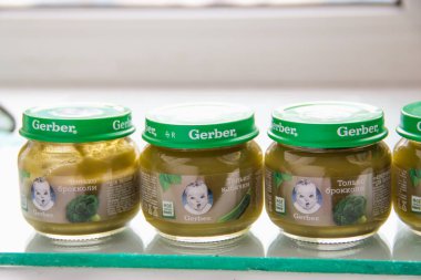 MOSCOW, RUSSIA - SEPTEMBER 12, 2020: masanın üzerinde çocuk beslenme sebze püresi olan cam kavanozlar. Brokoli ve kabaklar beslenmek için. Pencerenin yanında gündüz fotoğrafı.