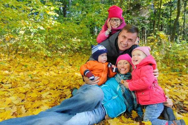 Glücklich lächelnde Familie entspannt im herbstlichen Park — Stockfoto