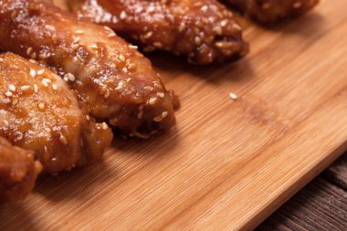 Tavuk kanadı: bal, susam, zencefil. Tahta bir masada..