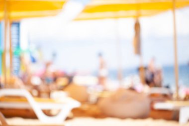 Güzel, yumuşak bir arka plan. Plaj ve güneş yatakları şemsiyelerin altında. odak dışı