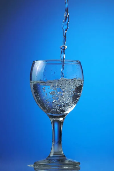 Wasser Füllt Ein Glas Auf Einem Dunkelblauen Farbverlauf Vor Einem — Stockfoto