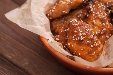 Tavuk kanadı: bal, susam, zencefil. Tahta bir masada..