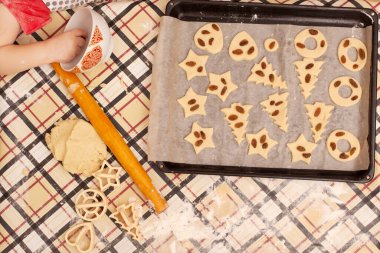 Masada kuru üzümlü ev yapımı kurabiyeler. Çocuk annesinin yemek yapmasına yardım eder.