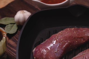 Tahta bir masada çiğ ördek göğsü. Izgara tavası. Lezzetli tarif. Yukarıdan görünen nesnelerin bileşimi