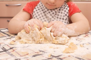 Masada kuru üzümlü ev yapımı kurabiyeler. Kızı annesinin yemek yapmasına yardım eder..
