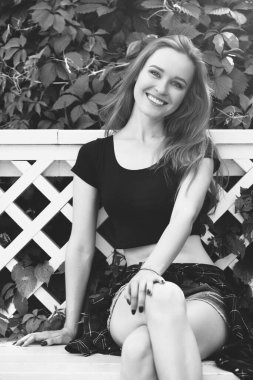 Şortlu genç bir kız ve şehirde siyah bir konu. Parlak duygular, yaşam tarzı, güneşli bir gün.