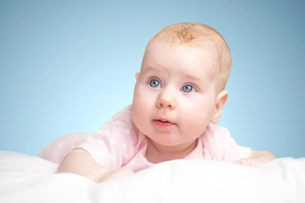 the little girl lies on a pillow - cloud. on a blue background.