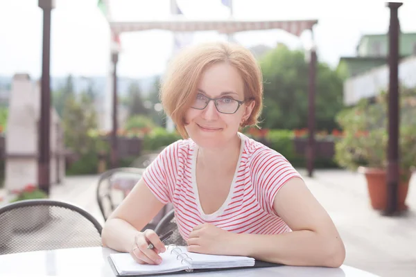 Une Jeune Fille Lunettes Assoit Une Table Prend Des Notes — Photo