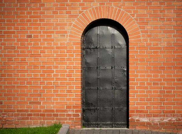 Parede Tijolo Vermelho Com Uma Porta Ferro Preto Grama Verde — Fotografia de Stock