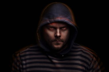 Siyah arka planda kapüşonlu bir adamın şeytani dramatik portresi.