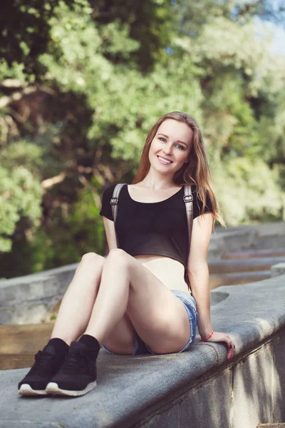 Şortlu genç kız, merdivenlerde oturuyor. duygusal portre. Yaşam tarzı