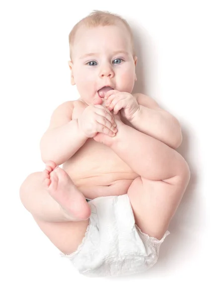 Malé Krásné Bělošské Dítě Leží Zádech Olizuje Nohu Izolované Bílém — Stock fotografie
