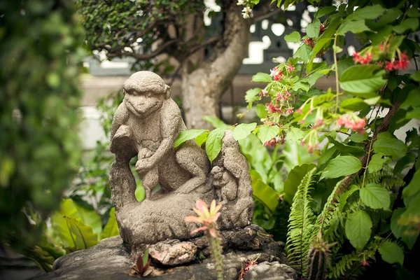 Die Steinfigur Eines Affen Ist Von Grün Und Farben Umgeben — Stockfoto