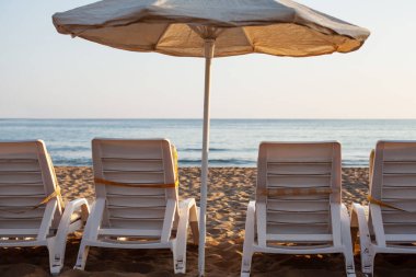 Bedava güneş şezlongları ve kumsalda güneşlenme yatakları. parlak yumuşak fotoğraf