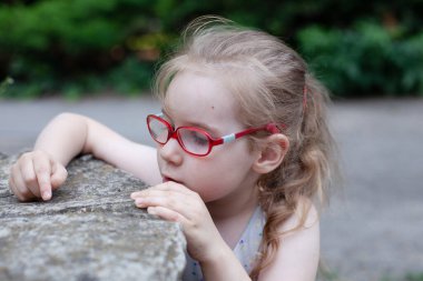 Gözlüklü güzel kız dünyayı inceliyor.