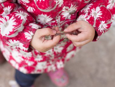 Elinde solucan tutan küçük bir kız, tuhaf bir çocukluk.