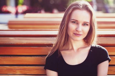 Şortlu genç bir kız, bankta oturuyor. duygusal portre. Yaşam tarzı