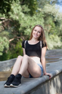 Şortlu genç kız, merdivenlerde oturuyor. duygusal portre. Yaşam tarzı