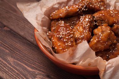 Tavuk kanadı: bal, susam, zencefil. Tahta bir masada..