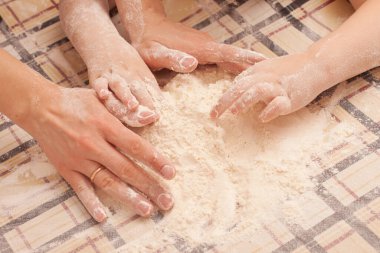 Masada kuru üzümlü ev yapımı kurabiyeler. Kızı annesinin yemek yapmasına yardım eder..