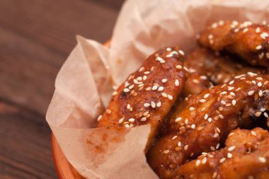 Tavuk kanadı: bal, susam, zencefil. Tahta bir masada..