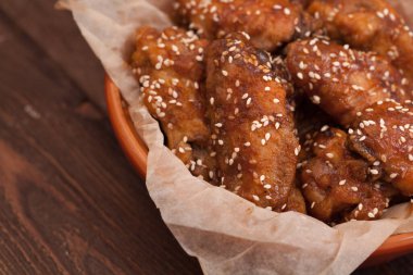 Tavuk kanadı: bal, susam, zencefil. Tahta bir masada..