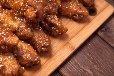 Tavuk kanadı: bal, susam, zencefil. Tahta bir masada..