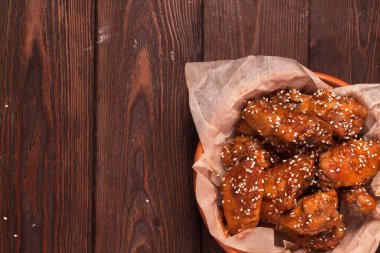 Tavuk kanadı: bal, susam, zencefil. Tahta bir masada..